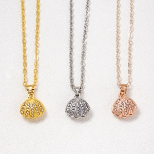 Elegant scallop shell pendants in gold, silver, and rose gold with zircon inlay