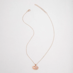 Detail of rose gold scallop pendant with sparkling crystals and a central white pearl