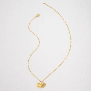 Detail view of scallop shell pendant necklace featuring tiny crystals and a white pearl