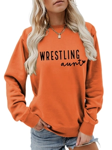 Close-up of orange round neck sweatshirt with black WRESTLING aunt print and ribbed cuffs
