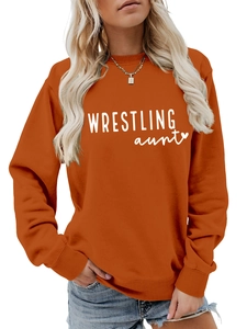 Caramel orange sweatshirt detail featuring white Wrestling Aunt text and heart print