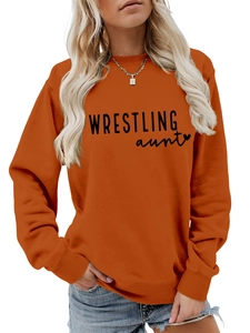 Close-up of ribbed cuffs and Wrestling Aunt black lettering on orange sweatshirt