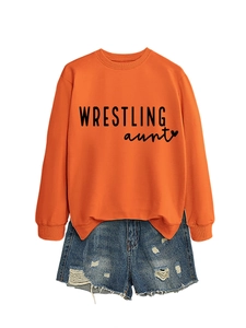 Detail showing orange crewneck sweatshirt with Wrestling Aunt print and denim shorts