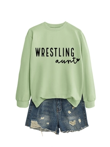 Flat lay of light green crewneck sweatshirt with Wrestling Aunt print and ripped denim shorts