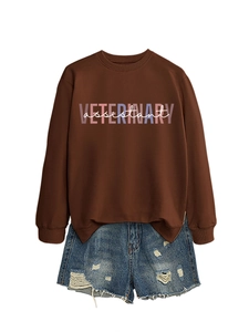 Dettaglio felpa caffè scuro con stampa Veterinary Assistant e pantaloncini in denim