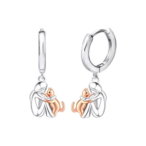 Detail view of S925 silver hoop earrings featuring a girl hugging a rose gold cat charm