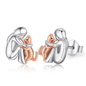 Detail of silver and rose gold girl hugging cat earrings with metallic backings