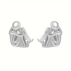Polished silver girl hugging dog stud earrings showing metallic texture and details