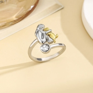 Silver girl hugging golden dog ring with a sparkling clear round birthstone detail