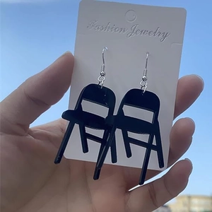 Creative black acrylic mini folding chair earrings with silver hooks against a blue sky
