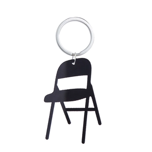 Detailed macro view of creative black acrylic folding chair keychain on white background