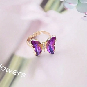 Detailaufnahme des violetten Schmetterlingsrings mit goldener Schiene und Kristallakzenten