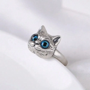 Macro shot of 3D cat head ring with realistic fur texture and bright blue gem eyes