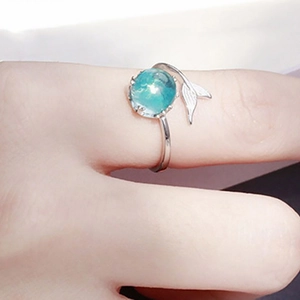 Mermaid tail open ring with sea blue bead on a silver band shown on hand