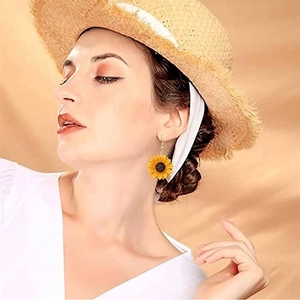 Gros plan d'une boucle d'oreille tournesol sur un mannequin avec des pétales jaunes