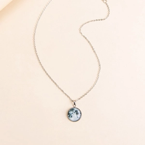 Minimalist silver chain necklace with a realistic glowing moon pendant under glass dome