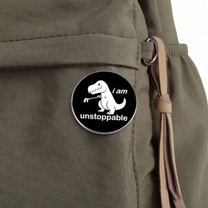 Spilla dinosauro T-Rex con scritta I Am Unstoppable su uno zaino in tela verde