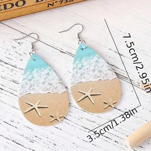 Detail of teardrop ocean wave earrings with starfish print on white wood background
