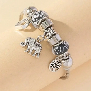 Silver elephant and tree of life charm bracelet with floral beads on a beige base