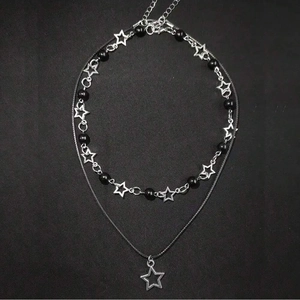 Detail of double-layer punk necklace with hollow stars, black beads and leather cord