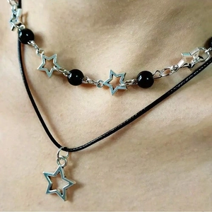 Double-layered necklace featuring black beads and silver star pendants on a black leather cord