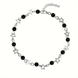 Detail of minimalist black beads and silver star pendant with lobster clasp and chain