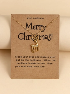 Detail of golden reindeer pendant necklace on Merry Christmas gift card packaging