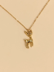 Close-up of a polished gold reindeer pendant on a delicate link chain necklace
