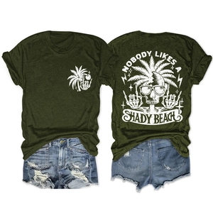 Flat lay of dark green t-shirt with shady beach print and distressed denim shorts