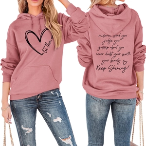 Detail view of pink hoodie showing 'Let them' heart print and motivational text on the back