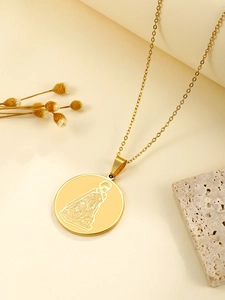 Vue macro du pendentif en acier doré avec gravure de figure sacrée sur plateau en pierre