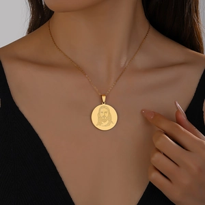 Détail du pendentif rond en acier inoxydable doré avec portrait gravé de Jésus