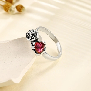Bague paresseux argentée rétro avec une pierre précieuse cœur rouge sur socle blanc