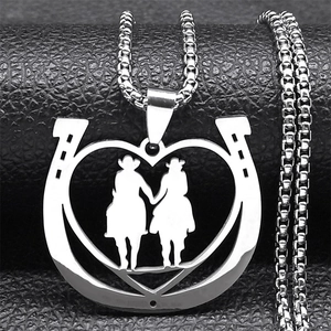 Detail of horseshoe heart pendant necklace with double equestrian riders on box chain
