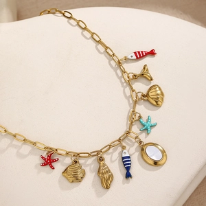 Golden ocean theme necklace featuring fishtail, seashell and starfish charms on a link chain
