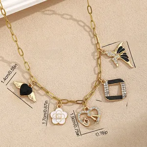 Detailed view of paperclip chain necklace with black heart and pearl flower charms