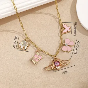 Detail of gold chain necklace with pink charms like sweet candy bag and heart wings