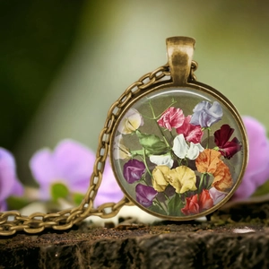 Collier vintage en bronze avec pendentif fleur en verre posé sur un bloc de bois