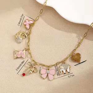 Detail of gold chain necklace featuring colorful butterfly, swan, and candy charms