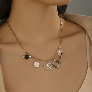 Macro shot of gold multi-pendant necklace with shell and heart charms on neck