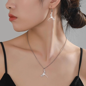 Minimalist stainless steel dragonfly jewelry set with hollow-out design on a model