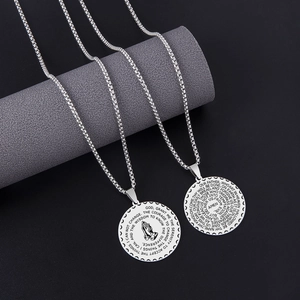 Detail of silver stainless steel prayer hands disc pendant with engraved Serenity Prayer