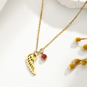 Collar dorado con ala de ángel calada y colgante de piedra de nacimiento roja