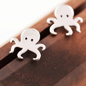Macro shot of silver octopus stud earrings with cute details and polished finish