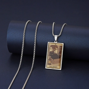 Detailed shot of IX The Hermit Tarot necklace with black cat pendant on a blue pedestal