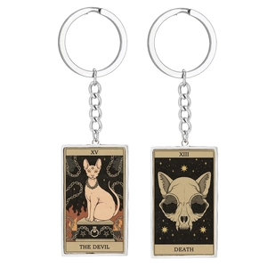 Close-up of cat tarot keychains featuring The Devil and Death in vintage metal frames
