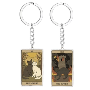 Detailed view of cat tarot keychains featuring The Lovers and The Tower illustrations