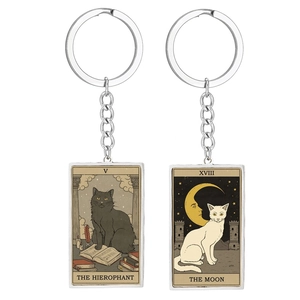 Detail of Tarot cat keychains showing The Hierophant and The Moon designs in metal frames