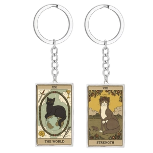 Detail of The World and Strength tarot card cat keychains in silver metal frames