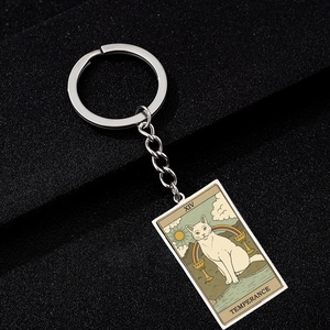 Close-up of silver cat tarot keychain featuring the XIV Temperance oil painting charm